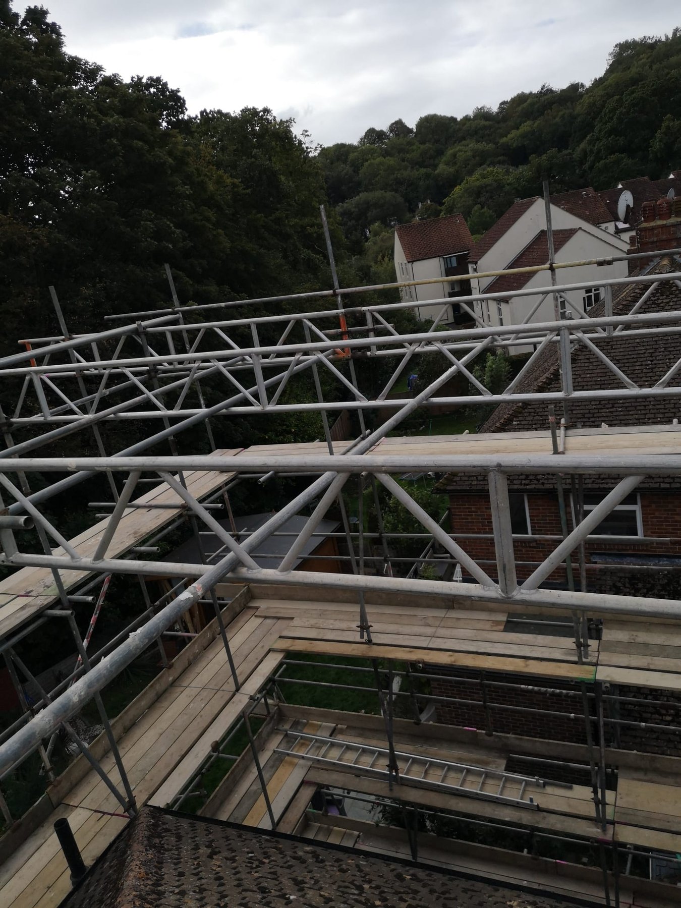 View down through scaffold trusses onto neighbouring roofs